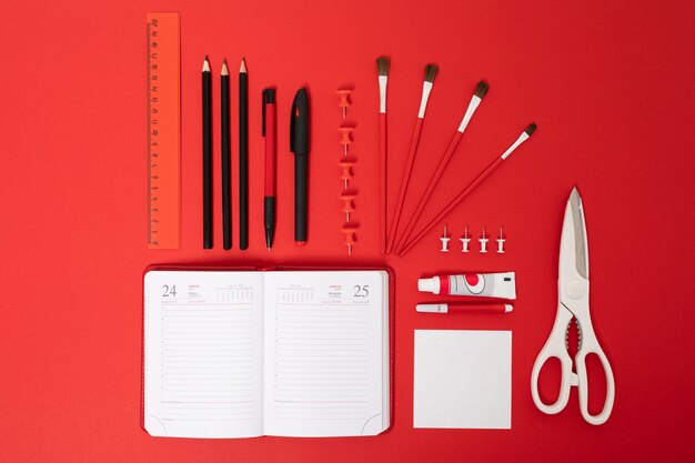 School and office supplies lie neatly on a red table