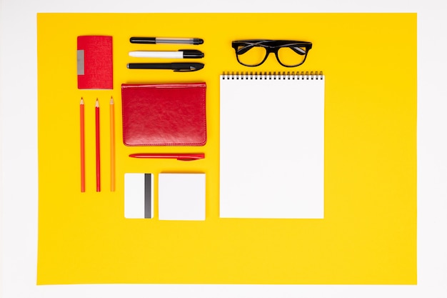 Photo school and office supplies lie neatly on a yellow wall