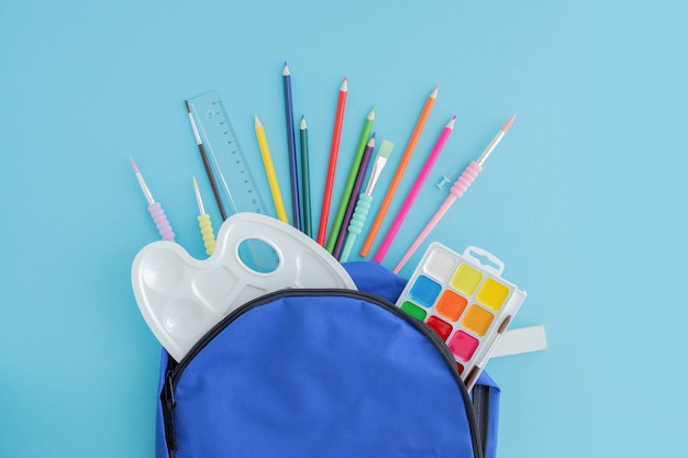 Photo school, office supplies poured from a blue backpack or knapsack