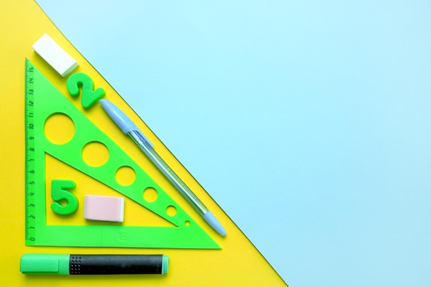 School  office supplies triangle marker eraser pen on a colored background copy space back to school