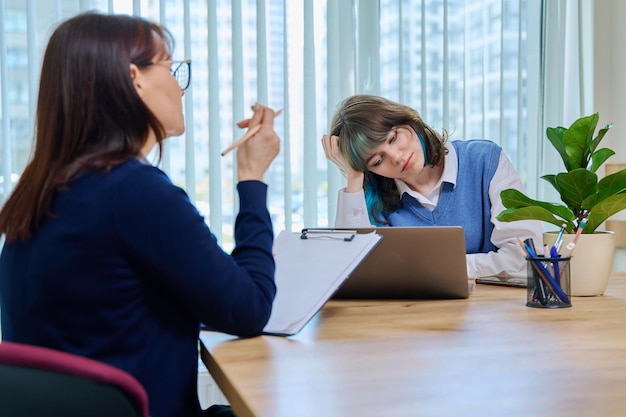 school psychologist supporting girl student sitting in office of educational building