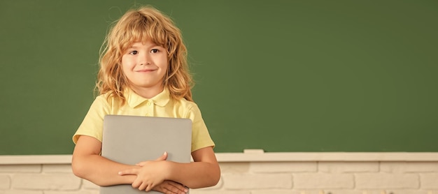 Photo school pupil boy on blackboard banner copy space elearning child studying with computer cheerful