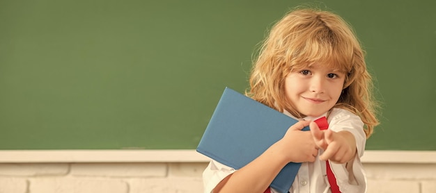 School pupil boy on blackboard banner copy space happy teen boy\
in classroom back to school knowledge day concept of education