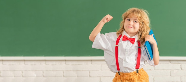 School pupil boy on blackboard banner copy space knowledge day concept of education nerd kid with long hair at blackboard september 1