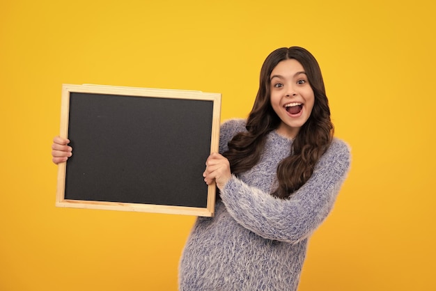 School sales board Cheerful teenage girl kid hold blackboard chalkboard with copy space Amazed teenager Excited teen girl