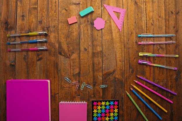 Школьный набор с цветными ручками и карандашами на деревянном фоне