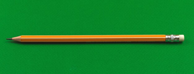 Foto cancelleria scolastica, matita gialla scolastica con gomma su sfondo verde tavolo, foto banner