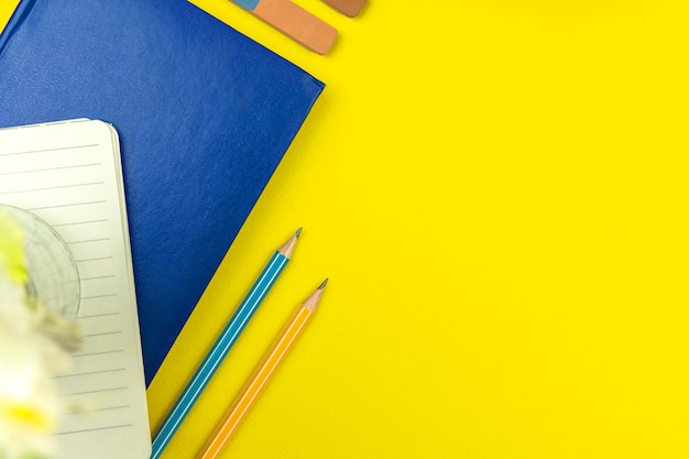 School students workspace background with yellow desktop top view, copy space photo