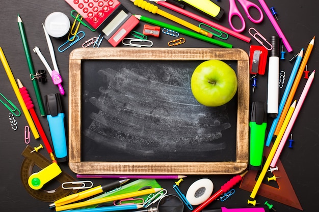 School supplies on black background. Flat layout.