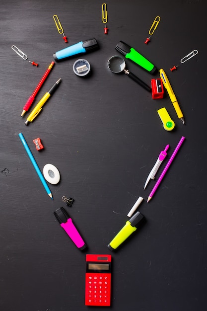 School supplies on black background. Flat layout.