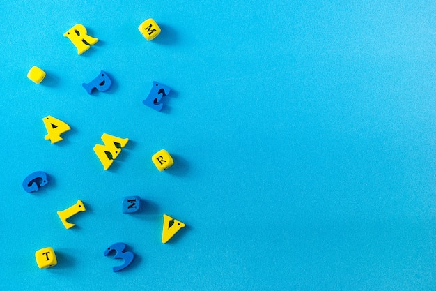 School supplies on a blue background. School and teacher day concept. Wooden letters on the table with copy space .