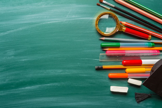 School supplies on chalkboard 