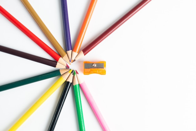 Школьные принадлежности и цветные карандаши на белом