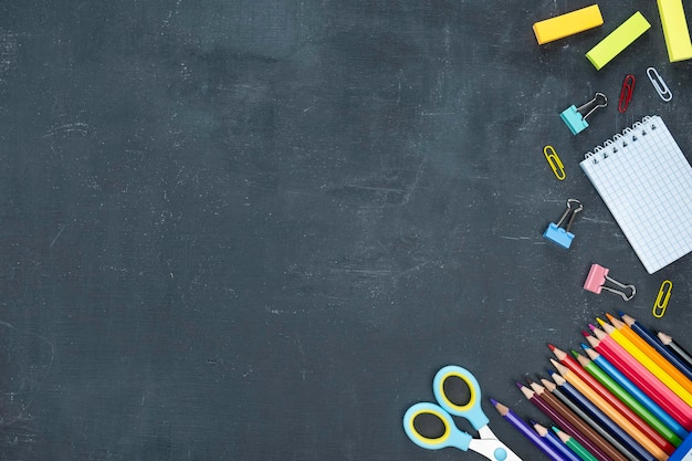 Foto forniture scolastiche su sfondo scuro concetto di ritorno a scuola spazio testo vista dall'alto