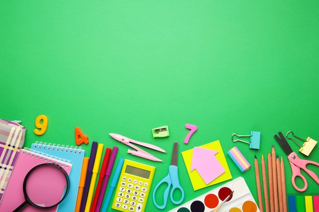 School supplies on green background with copy space. Back to school concept.