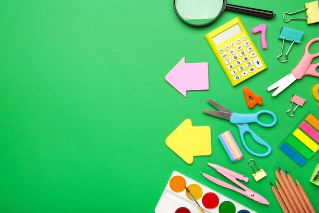 School supplies on green background with copy space. Back to school concept.