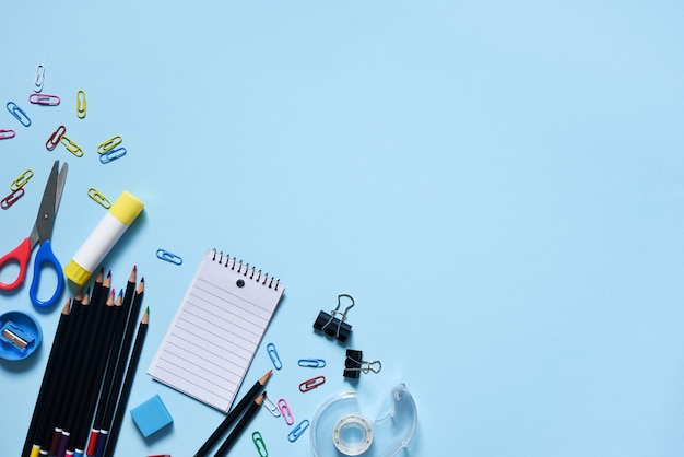 School supplies and mask on a blue background Layout of school accessories Back to school Distance learning