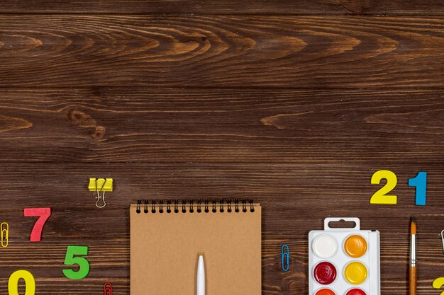 School supplies office supplies on a dark wood background Flat lay top view Place for an inscription