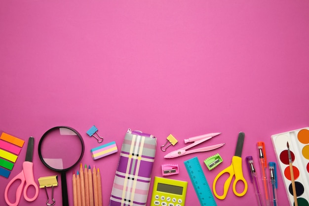 School supplies on pink background. Back to school concept.