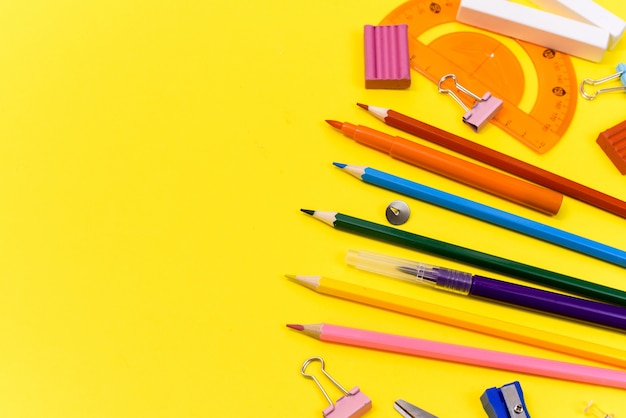 School supplies stationery on yellow background. View from above