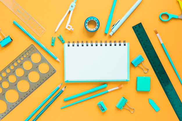 School supplies with blank notebook in center