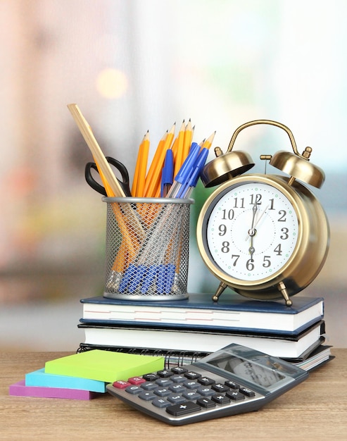 School supplies with clock on wooden table