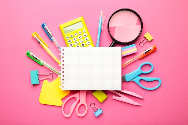 School supplies with notebook on pink background. Back to school. Flat lay. Top view