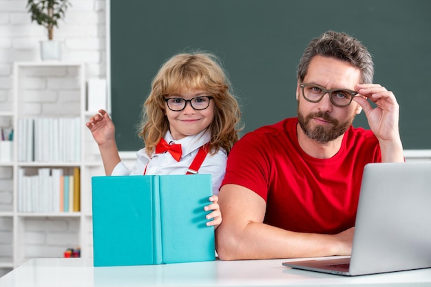 School teacher and child pupil in classroom funny happy elementary school boy