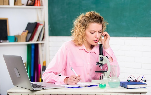 학교 교사는 매일 공부를 계속합니다. 학교로 돌아갑니다. 학교 실험실은 공부를 위한 장비입니다. 미생물학을 공부합니다. 분자 변형을 조사합니다. 노트북과 현미경을 가진 학생 소녀입니다.
