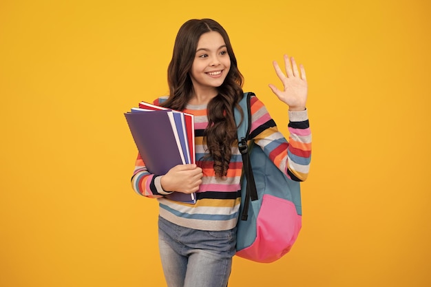 School teenager child girl with book and copybook teenager student isolated background learning and knowledge go study education concept happy teenager positive and smiling emotions
