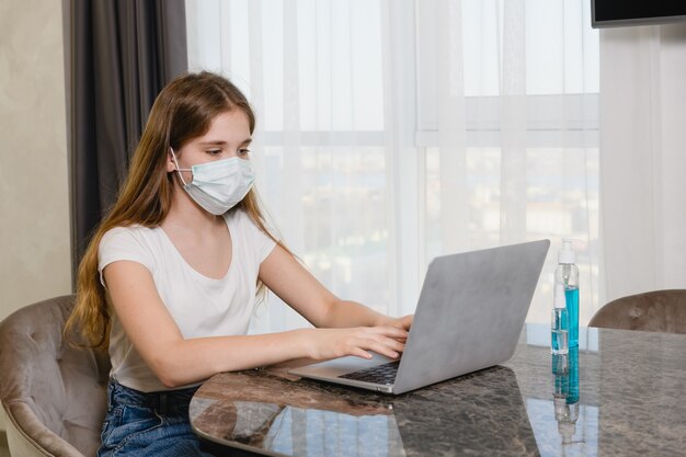 School university distance learning work by internet in condition of world coronavirus epidemic, wearing medical mask, use sanitizer at home