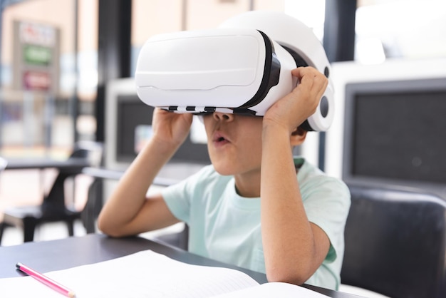 in school young biracial male student wearing virtual reality headset in the classroom
