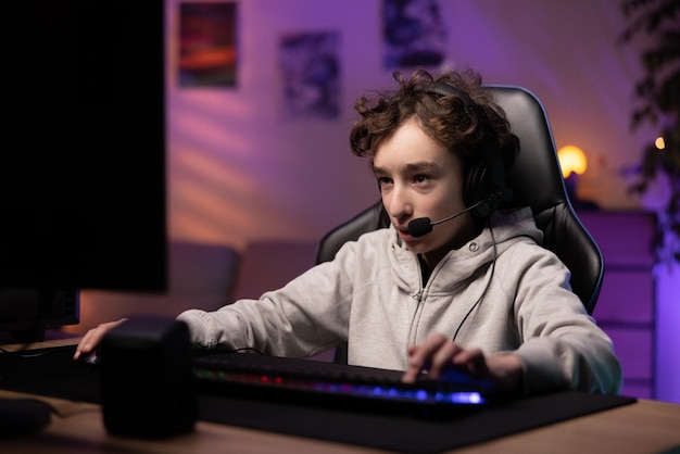 Schoolage boy pro gamer spends time playing computer games