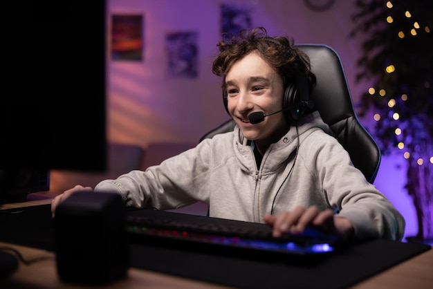 Schoolage child pro gamer spends time in front of the monitor playing computer games