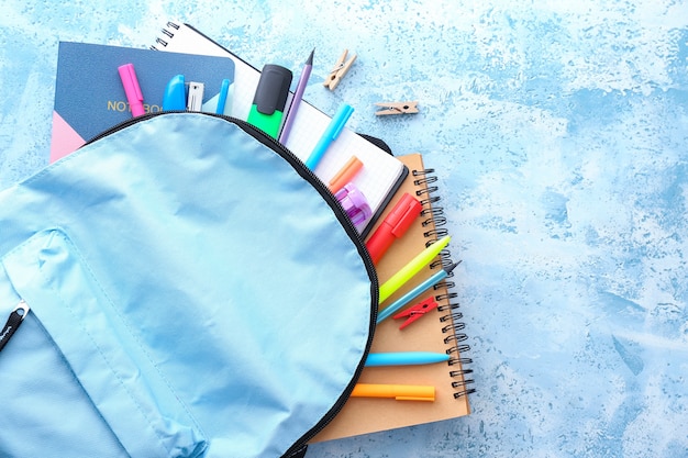 Schoolbag with stationery on color