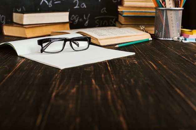 Schoolbank in de klas, met boeken op de achtergrond van krijt bord met schriftelijke formules