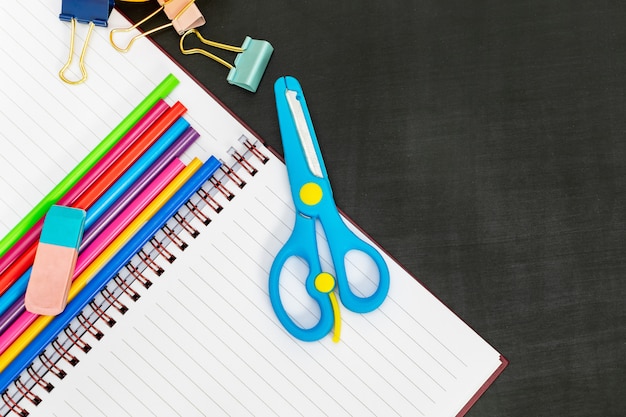 Schoolbenodigdheden met notitieboekje, schaar, paperclips, kleurpotloden