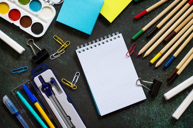 Schoolbenodigdheden op een zwarte tafel