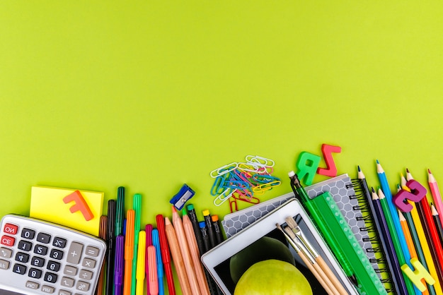 Schoolbenodigdheden op groene achtergrond