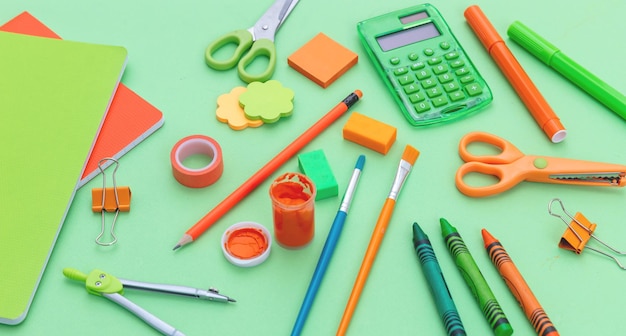 Schoolbenodigdheden op groene kleur achtergrondweergave van bovenaf