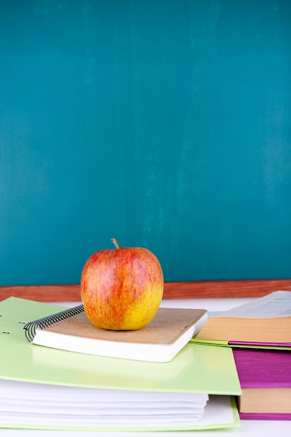 Schoolbenodigdheden op tafel op schoolbordachtergrond