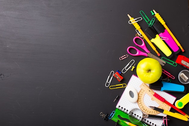 Schoolbenodigdheden op zwarte achtergrond. Vlakke indeling.