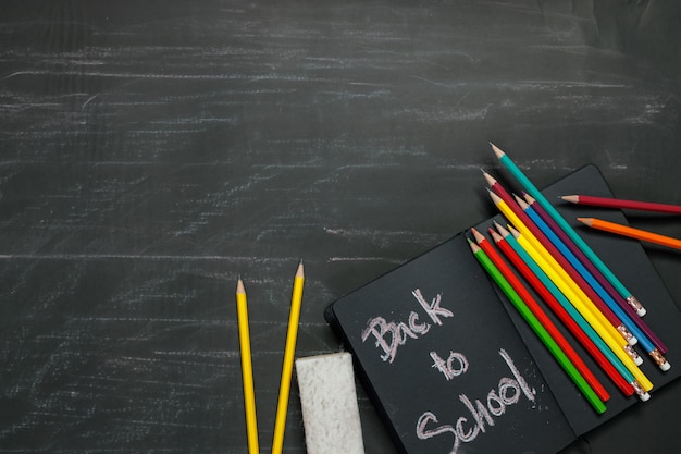 Schoolbenodigdheden op zwarte bord achtergrond. Terug naar school-concept.