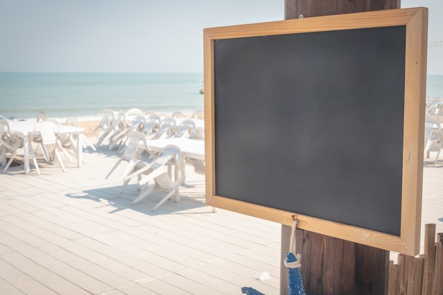 Schoolbord met houten frame met zandstrand achtergrond