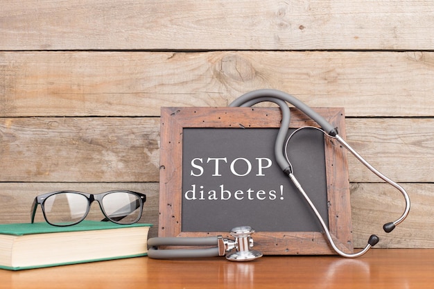 Schoolbord met opschrift STOP diabetes stethoscoop boek bril