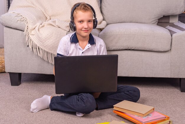 schoolboy boy makes homework on a laptop online learning