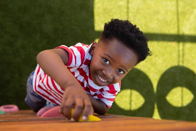 Photo schoolboy climbing a wall in the school playground