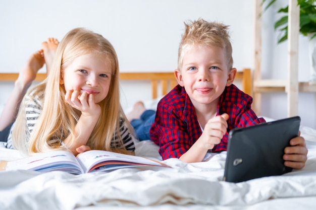 Schoolboy and girl studying at home with digital tablet.