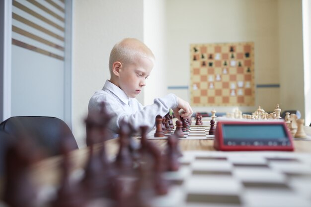 Schoolboy hesitating in chess