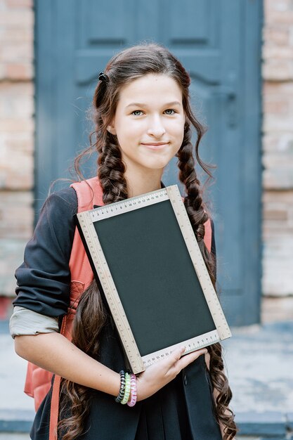 A schoolboy holding a chalk board